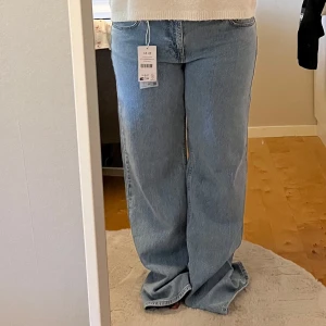 Ljusblå jeans från NA-KD - Säljer dessa populära ljusblå jeans från NA-KD med breda ben och klassisk femficksdesign. Perfekta för dig som gillar en avslappnad och trendig look. Helt nya, inte använda. Har både lapp och orginalförpackning kvar. Innerbenslängden är 80 cm (ser så långa ut pga mina korta ben)💕 Nypris 799kr.