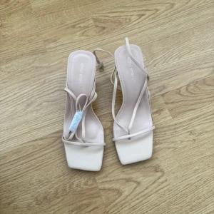 Beige sandaler med smala remmar och klack - Snygga beige sandaler från Ideal Shoes med smala remmar och fyrkantig tå. Skorna har låg klack och öppen tå. Nypris 569 men slutsålda. Helt oanvända ena skon är bara testad. 