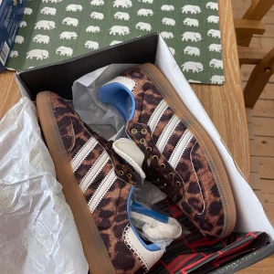 Adidas Wales Bonner leopard sneakers - Unika Adidas Wales Bonner sneakers med leopardmönster i bruna och beige toner, vita detaljer och blå insida. Klassiska tre ränder på sidan, grov vit plös med logga och bruna skosnören. Snygg gummisula och cool retrostil. Ingår vita skosnören. Kartongen har blivit kantstött i leveransen men inget som påverkat skorna!