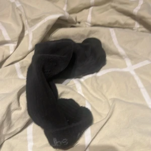 Svarta ribbade strumpor - Ett par svarta strumpor med ribbad struktur. Klassisk modell som passar till sneakers eller boots. Mjukt och bekvämt material, perfekta för vardagsbruk.