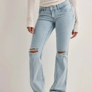 Ljusblå bootcut jeans med slitningar - Populära jeans från Nelly, säljer då dom är lite stora. Använda några gånger men man märker ingenting på kvaliteten. Pris kan diskuteras 