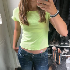 Ljusgul ribbad topp i xxs  - Somrig ljusgul ribbad topp med korta ärmar och ”volangkant” i storlek 146/152. Toppen kan bäras både på axlarna och som en offshoulder. Endast använd ett fåtal gånger, alltså inga defekter.