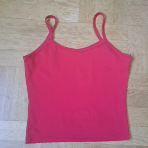 Röd linnetopp med smala axelband - Enkel och snygg röd linnetopp med smala axelband och rak passform. Storlek uppskattad till xs, eventuellt s. 