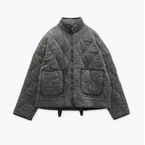 Grå quiltad jacka med dragkedja - Säljer en grå quiltad jacka med oversized passform och stora fickor framtill. Jackan har hög krage, lång ärm och stängs med dragkedja. Perfekt för dig som gillar en chill och trendig look till höst och vår. Storlek Xs men passar också S