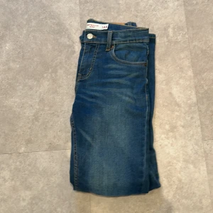 Levi's 502 Regular Taper jeans blå - Snygga blå Levi's 502 Regular Taper jeans med klassisk femficksdesign och gul kontrastsöm. Jeansen har en avsmalnande passform och är tillverkade i slitstarkt denim. Perfekta för dig som gillar en tidlös och clean look.