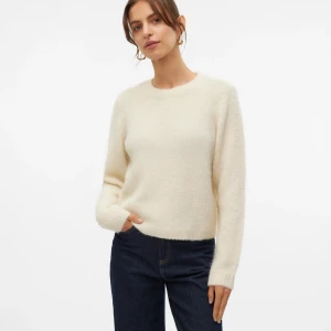 Krämvit stickad tröja med rund hals - Mysig krämvit stickad tröja med rund halsringning och långa ärmar. Tröjan har en enkel och stilren design som passar perfekt till jeans eller kjol. Den är fluffig och mjuk, vilket gör den extra skön att bära under kyliga dagar.