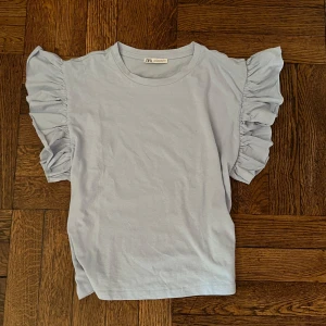 ljusblå volangtopp från zara - snygg ljusblå topp från zara med korta ärmar och stora volanger som ger en fin somrig känsla, använd fåtal gånger😍❣️