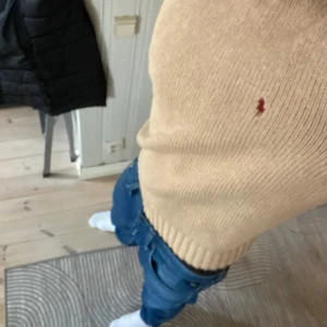 Beige stickad tröja från Polo Ralph Lauren - Snygg beige stickad tröja från Polo Ralph Lauren i 100% bomull. Lite stor i storleken