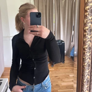 Svart topp med knappar - Snygg svart stopp med knappar där fram. Använd fåtalet gånger så i fint skick. Säljer då den inte kommer till användning. Storlek L men stretchigt material så passar t.ex mig bra, som vanligtvis har S i tröjor. Hör av dig vid frågor, pris går att diskutera🫶