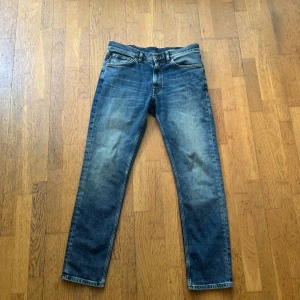 Gant blå jeans slim fit - Säljer ett par klassiska gant jeans i blå denim med snyggt slitna detaljer och raka ben. Jeansen har fem fickor, normal midja och är tillverkade i bomull. Perfekta för dig som gillar en tidlös och avslappnad stil.
