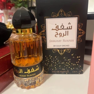 Shaghaf Alrouh Eau de Parfum 100ml - Shaghaf Alrouh från Gulf Orchid är en Eau de Parfum i en lyxig, kristallformad glasflaska med svart och guld detaljer. Doften har en varm bärnstensfärgad vätska och levereras i en elegant svart kartong med guldmönster. Flaskan rymmer 100 ml och har en dekorativ svart kork. En arabisk oud doft som är hur god som helst, passar både män och kvinnor. För mer lyxiga och eleganta tillfällen. 