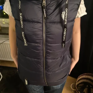Mörkblå dunväst från Navahoo - Säljer en snygg mörkblå dunväst från Navahoo med dragkedja och huva.