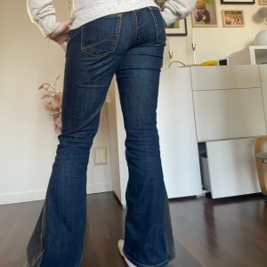 Lågmidjade jeans - Snygga mörkblå jeans med en lågmidja och en  omsydd bootcut, hin på bilden är 158cm och brukar ha xs 🌸🌸