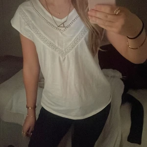 Vit tröja med spetsdetaljer - Säljer en söt vit topp med vackra spetsdetaljer runt halsringningen. Toppen har korta ärmar och en avslappnad passform, perfekt för en vår/sommardag💕 materialet är väldigt mjukt, inte det ”typiska” T-shirt materialet🫶🏼 står storlek xs, men eftersom den är ganska lös i passformen så passar den även S/M💗