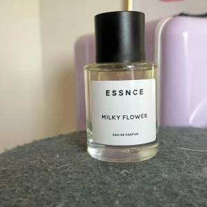 Essnce Milky Flower Eau de Parfum - Säljer en elegant flaska med Essnce Milky Flower Eau de Parfum. Flaskan är genomskinlig med en stilren vit etikett och svart lock. Doften är blommig och krämig, perfekt för den som älskar en mjuk och inbjudande parfym. Testad men i princip full som ni ser 