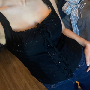 Svart söt topp - Snygg svart topp med knytning framtill och knappar. Perfekt för en stilren look. Smuts på !!spegeln!! på sista bilden!