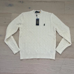 Vit kabel stickad tröja från Ralph Lauren - Kabelstikad tröja från Ralph lauren. Aldrig använd bara testad på. Säljs pga den var för liten. Perfekt till våren. Skriv vid minsta frågor!(pris går att diskuteras vid snabb affär 