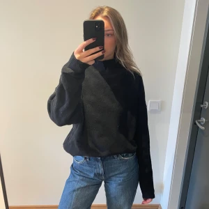 Svart tröja från Gina Tricot - Säljer en svart tröja från Gina Tricot i storlek M. Tröjan har en normal passform med långa ärmar och en hög krage. Perfekt för kyligare dagar.