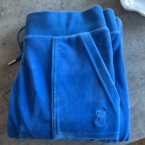  Juicy Couture Blå mjukisbyxor med fickdetalj - Snygga blåa Juicy Couture mjukisbyxor i stolek XS. Det är i bra skick. Andvänt två till tre gånger.