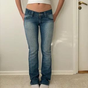 Blå jeans från Levi's - Jätte snygga lågmidjade bootcut jeans från Levis!! Aldrig använda av mig! I storlek W25 som motsvarar xs! Hon på bilden är 160cm för referens!