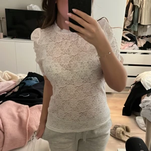 Vit spetsblus - Säljer en oanvänd vit spetsblus med korta ärmar. Perfekt för en stilren look. Blusen har en tight passform och är perfekt för vår och sommar 🌸☀️