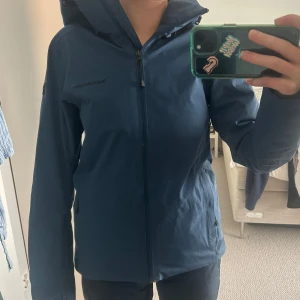 Blå skidjacka Peak performance  - Sååå snygg blå skidjacka med huva och dragkedja. Jackan har en normal passform och långa ärmar. Jättebra skick! Nypris ca 3000-4000 kronor