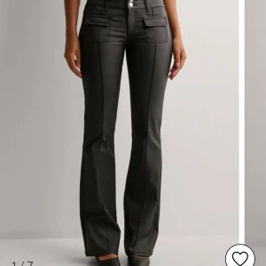 Svarta fakeskinn byxor med fickdetaljer - Svarta fakeskinnabycor men låg midja och bootcut. Använda ca 5 ggr. Dem är storlek 38 men passar mig som är en 36.