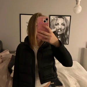 Svart pufferjacka - Säljer en svart pufferjacka med croppad passform. Jackan har långa ärmar och en dragkedja framtill. Aldrig använd!