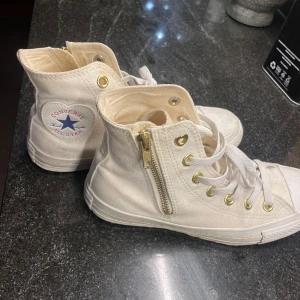 Vita sneakers från Converse - Säljer ett par vita Converse sneakers med snörning och dragkedja på sidan. Klassisk hög modell med Converse All Star-logga på sidan. ❤️