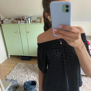 Svart offshoulder prickig topp - Säljer en mörkblå offshoulder topp med vita prickar. Toppen har korta ärmar och en luftig, flowy passform.💞