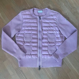 Moncler cardigan - Säljer en jättesnygg ljusrosa Moncler cardigan i mycket bra skick. Har inte hittat några defekter alls. Äktehetsbevis visas på bilderna. Storlek S