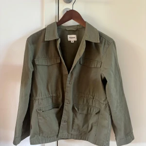 Grön jacka - Grön jacka som funkar perfekt till sommar, höst eller vår. Använd fåtal gånger. Den har ett snöre inuti som gör att man kan dra in midjan. 