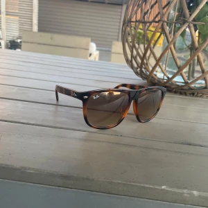Ray-Ban Boyfriend brunmelerade solglasögon - Snygga Ray-Ban Boyfriend med brunmelerad båge och mörka glas. Klassisk fyrkantig form och coolt mönster som sticker ut. Tillverkade i Italien och perfekta för soliga dagar.