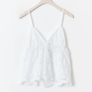 Vit broderad linnetopp med spets - Superfin vit linnetopp med tunna axelband och v-ringning. Toppen har broderade blommor och spetsdetaljer, samt en vågig nederkant som ger en romantisk vibe. Perfekt för varma dagar och sommarhäng.