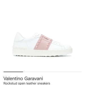 Valentino Garavani Rockstud sneakers - Snygga vita sneakers i skinn från Valentino Garavani med ikoniska ljusrosa Rockstud-detaljer över vristen. Skorna har platt sula, rund tå och en stilren design som sticker ut med sina nitar. Perfekta för dig som vill ha en lyxig och trendig look. (Skriv för bilder på skicket det är andvända i bra skick!)
