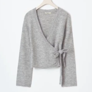 knitted wrap cardigan - Mysig grå omlottkofta från Monki med knyt i sidan och v-ringad hals. Koftan är stickad och har långa ärmar, perfekt för lager på lager. Enkel och stilren design som passar till många outfits.