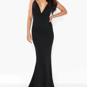 Svart långklänning med släp - Supersnygg svart långklänning med smala axelband och djup v-ringning framtill. Klänningen har figurnära passform och öppen rygg, vilket ger en elegant och stilren look. Perfekt för dig som vill sticka ut med en klassisk och tidlös stil