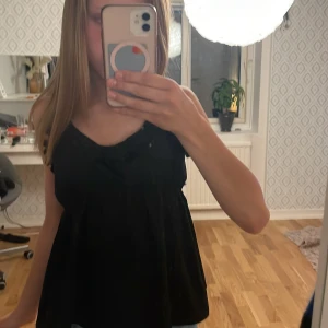 Somrig svart blus från lager! - Jag säljer en svart, somrig, och gullig blus med justerbara axelband, från Lager 157. Knappt använd, blusen är också rätt så liten i storlek! Köpt för minst 150kr, pris kan diskuteras!