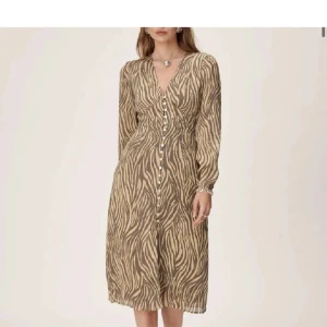 Adoore klänning - Snygg beige klänning med zebramönster och v-ringning från adoore. Knappt använd så i nyskick.