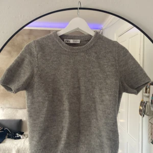 Stickad t shirt Zara - Grå stickad ”t shirt” från Zara i storlek S. Endast använd några gånger så knappt nopprig alls. Säljer då den är för liten och har då knappt använt den. Köpt för ungefär 350 tror jag därav priset. Kan gå ner till 200kr.