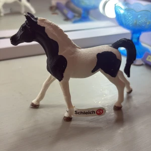 Svart och vit schleich häst - Bilderna visar en realistisk modellhäst från Schleich, svart och vit i färgen. Det är en detaljrik figur som passar perfekt för dig som älskar djur och samlar på hästfigurer. Perfekt för unga djurälskare och samlare!