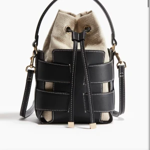 Viral H&M Väska, SVART - Säljer en snygg axelväska från H&M i svart skinn och beige bomull. Väskan har cool snörning upptill, guldfärgade detaljer och kontrastsömmar. Perfekt storlek för det viktigaste och har både handtag och axelrem. En riktigt trendig bucket bag för dig som gillar stilrena accessoarer. Helt slutsåld och går inte att få tag i, därav så högt pris! Knappt använt den, endast ett fåtal gånger. Stor efterfrågan! 💗🥰🙌🏼