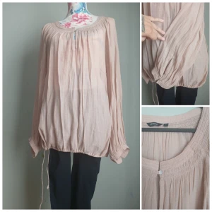 Ljusrosa bohemisk blus Generous by Lindex strl L - Ljusrosa, luftig blus från Generous by Lindex, strl L. Bohemisk stil med smock vid hals och ärmar, knapp framtill och dragsko nertill. Perfekt för både vardag och fest – bekväm, lätt och feminin. Mycket bra skick!