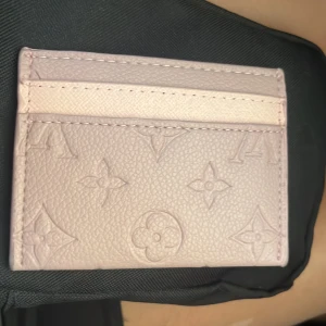 Louis Vuitton rosa kortfodral i skinn - Supersnyggt rosa kortfodral från Louis Vuitton i präglat skinn med klassiska LV-monogrammet. Perfekt storlek för kort och enkel att ha med sig i fickan eller väskan. Lyxig känsla och stilren design som sticker ut.