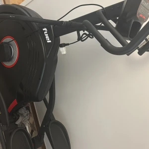 2000 - Bilderna visar en träningsmaskin (crosstrainer) av märket Fuel/Dyaco. Ingen bok syns på bilderna.