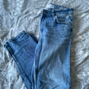 Blå raka jeans från Bershka - Snygga blå jeans från Bershka i klassisk rak modell. Jeansen har fem fickor, normalhög midja och stängs med dragkedja och knapp. Tillverkade i jeansmaterial med en lätt tvättad look som ger en avslappnad vibe.