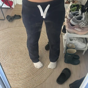 Marinblåa mjukisbyxor med snörning XS - Marinblåa mjukisbyxor från Russemerch i storlek XS. Byxorna har en vit snörning i midjan och är tillverkade i mjukt material, perfekta för chill dagar. De har en normal passform och muddar vid bensluten för en skön känsla. Låg i midian, dem har krympt till lite så skulle säga att dem är allt mellan xs/xxs. Inte använt heller så ofta så därför säljer jag dem