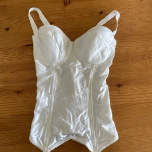 Vit korsett top - Säljer denna underbara korsett jag köpt på secondhand. Tyvärr är kuporna lite förstora för mig så den kommer inte till användning. Har endast testat den. Korsetten är i väldigt fint material och inga fläckar eller andra defekter tillkommer.💕