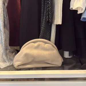 Soft goat, Beige väska - Supermjuk och fluffig beige kuvertväska med rundad form och minimalistisk design. Perfekt att hålla i handen och ger en chill men ändå trendig vibe. Väskan är i kashmir som känns cozy och unik.