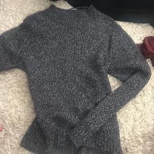 Blåvit stickad tröja Vero Moda - Mysig svartvit stickad tröja från Vero Moda i storlek XL men sitter normalt på mig som brukar ha xs. Tröjan har ett coolt melerat mönster, ribbad hals och muddar vid ärmslut och nederkant. Passformen är loose och den har långa ärmar, perfekt för att chilla eller hänga med kompisar.